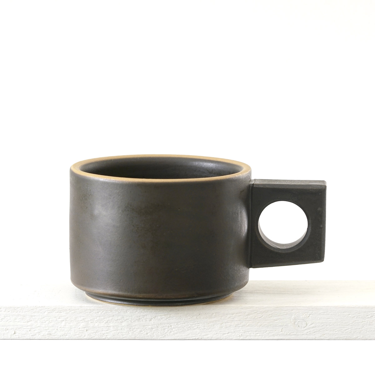 Seitenansicht einer kleinen Tasse mit einer matten, dunklen mokkafarbenenfarbenen Glasur