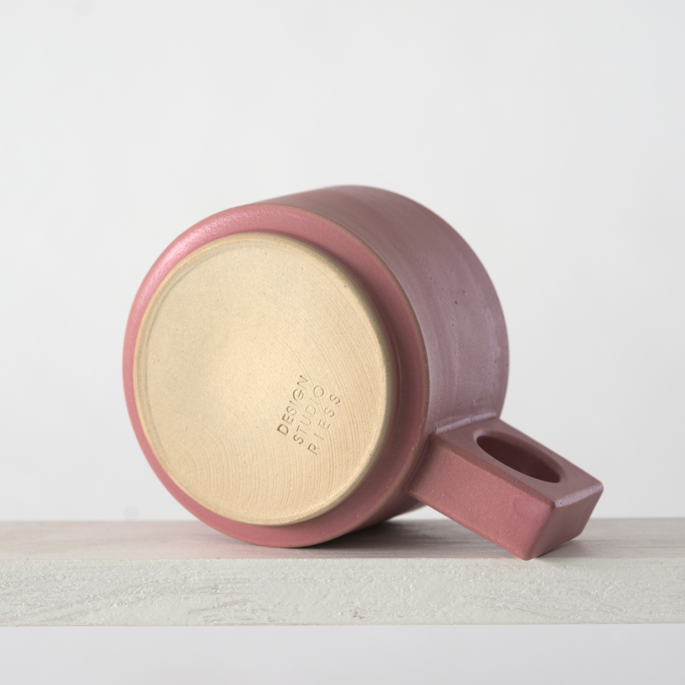 Unteransicht einer kleinen Tasse mit einer matten, rosa Glasur