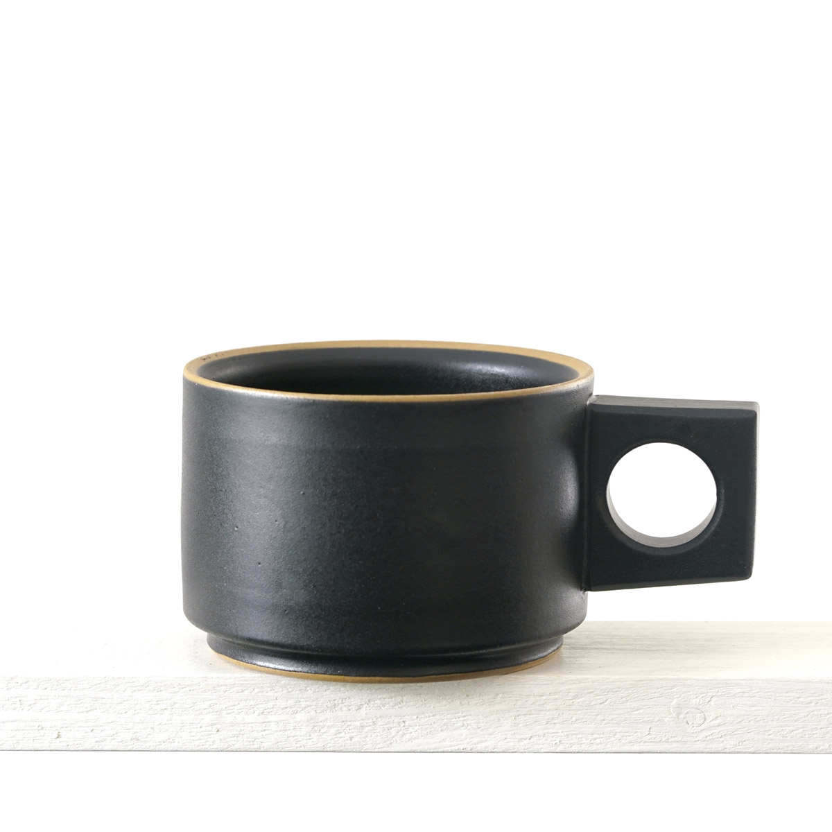 Seitenansicht einer kleinen Tasse mit einer matten, schwarzen Glasur