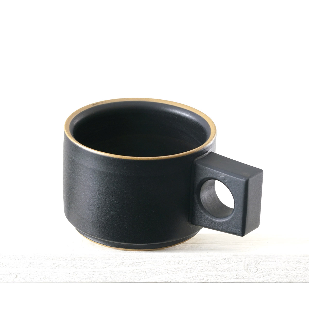 Schräge Ausicht auf eine kleinen Tasse mit einer matten, schwarzen Glasur