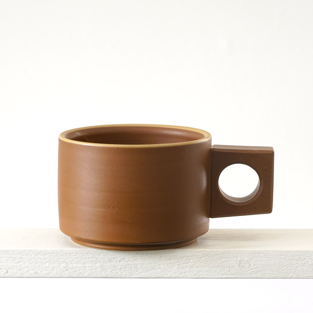 Seitenansicht einer kleinen Tasse mit einer matten, zimtfarbenen Glasur