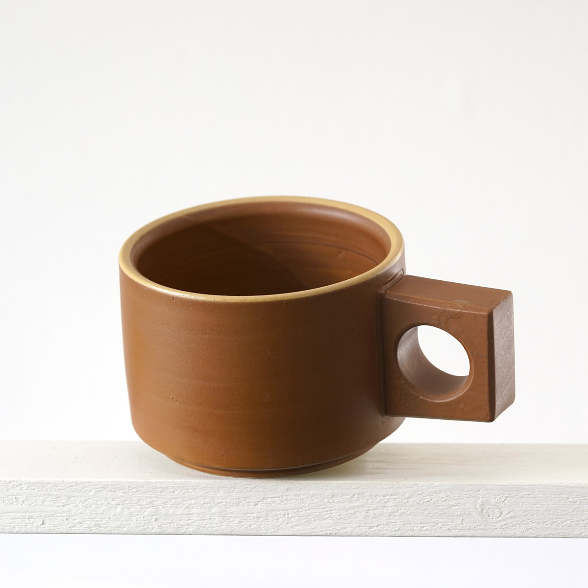 Schräge Ausicht auf eine kleinen Tasse mit einer matten, zimtfarbenen Glasur