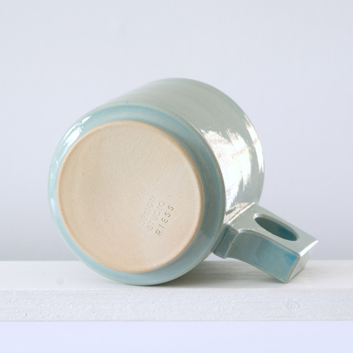 Unteransicht einer große Tasse mit einer glänzenden, hellblauen Glasur