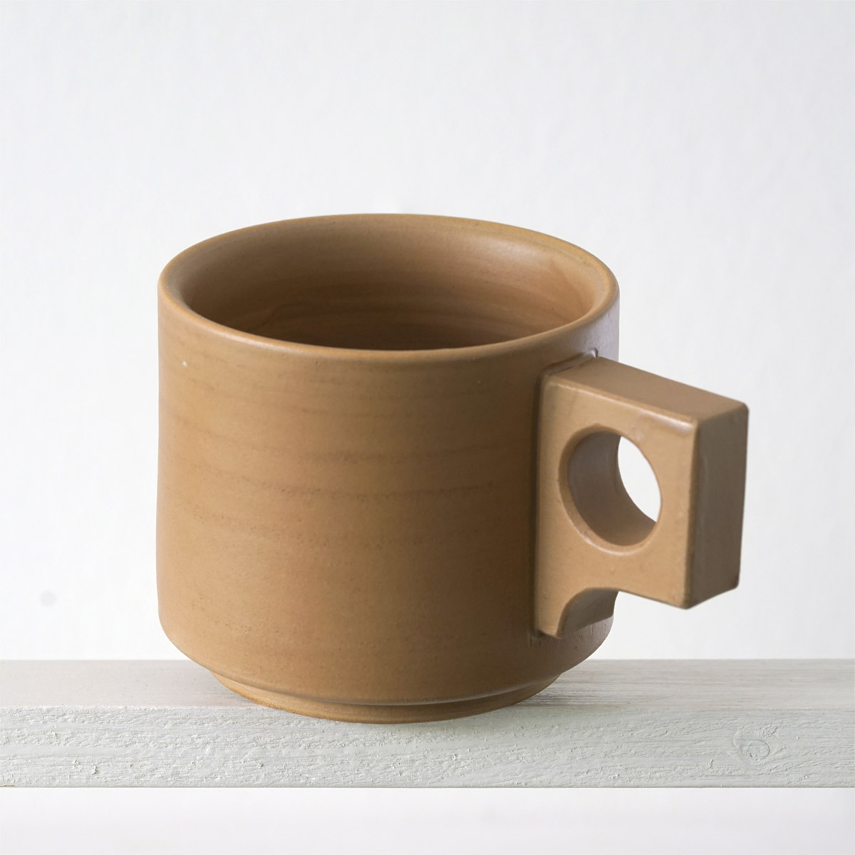 Schräge Ausicht auf eine große Tasse mit einer matten, karamellfarbenen Glasur