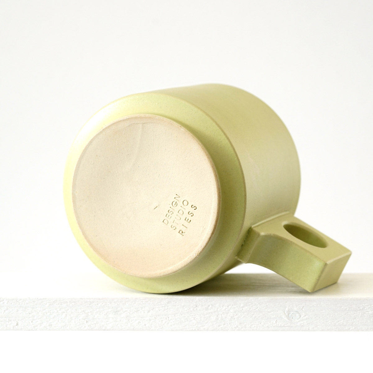 Unteransicht einer große Tasse mit einerur matten, limonenfarbenen Glasur