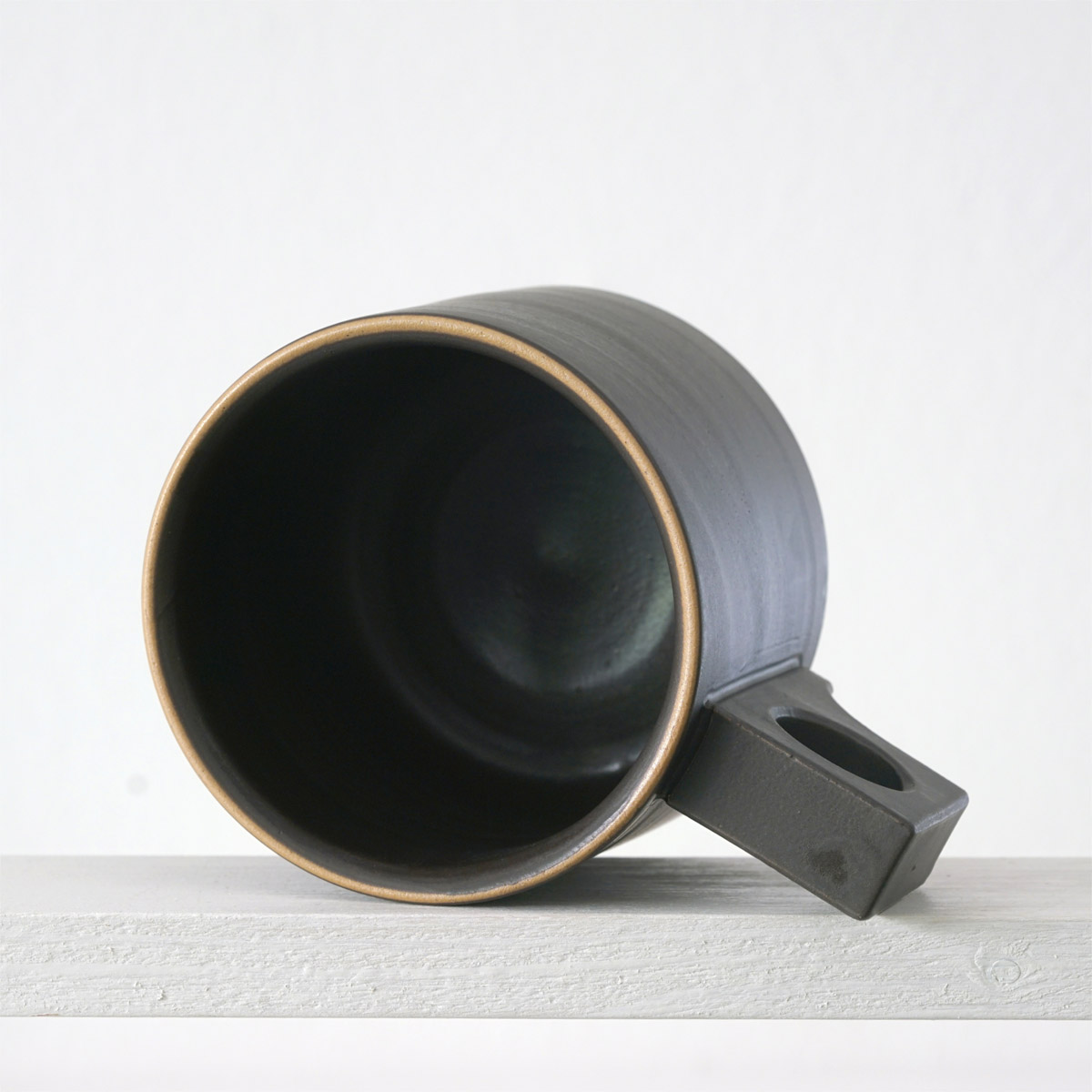 Sicht in eine große Tasse mit einer matten, dunklen mokkafarbenen Glasurn 