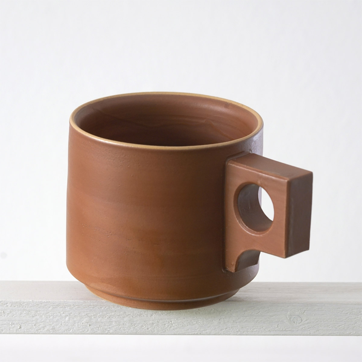 Schräge Ausicht auf eine große Tasse mit einer matten, zimtfarbenen Glasur